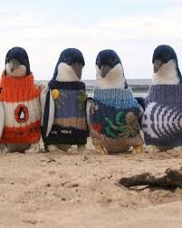 Four penguins in colorful patterned sweaters